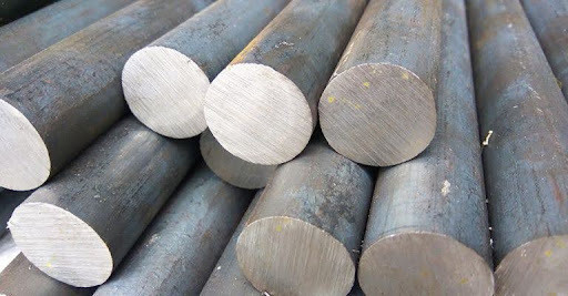 Stacked steel round bar stock ready for industrial heat treating services.